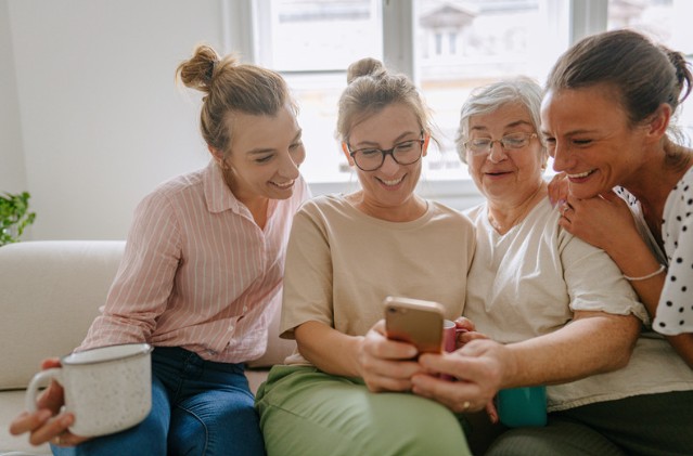 Group enjoying smartphone on the sofa together
